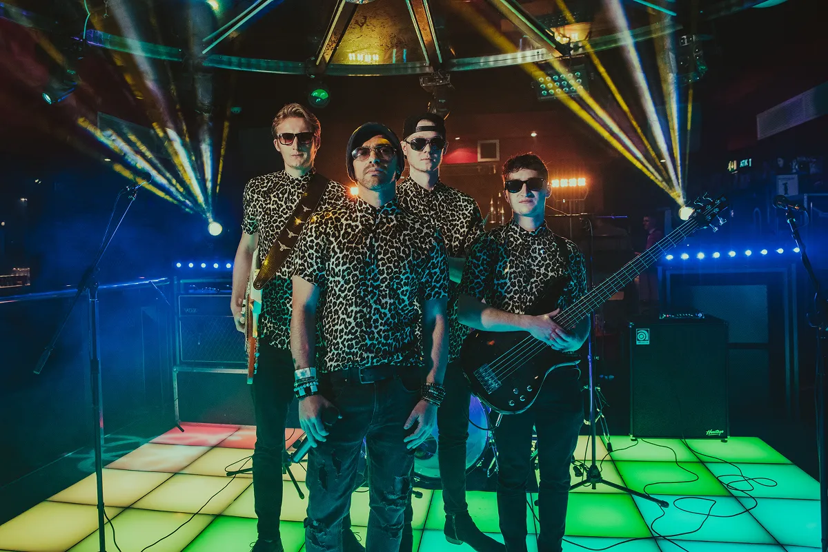 The Vegas Hooligans band posing on illuminated dance floor