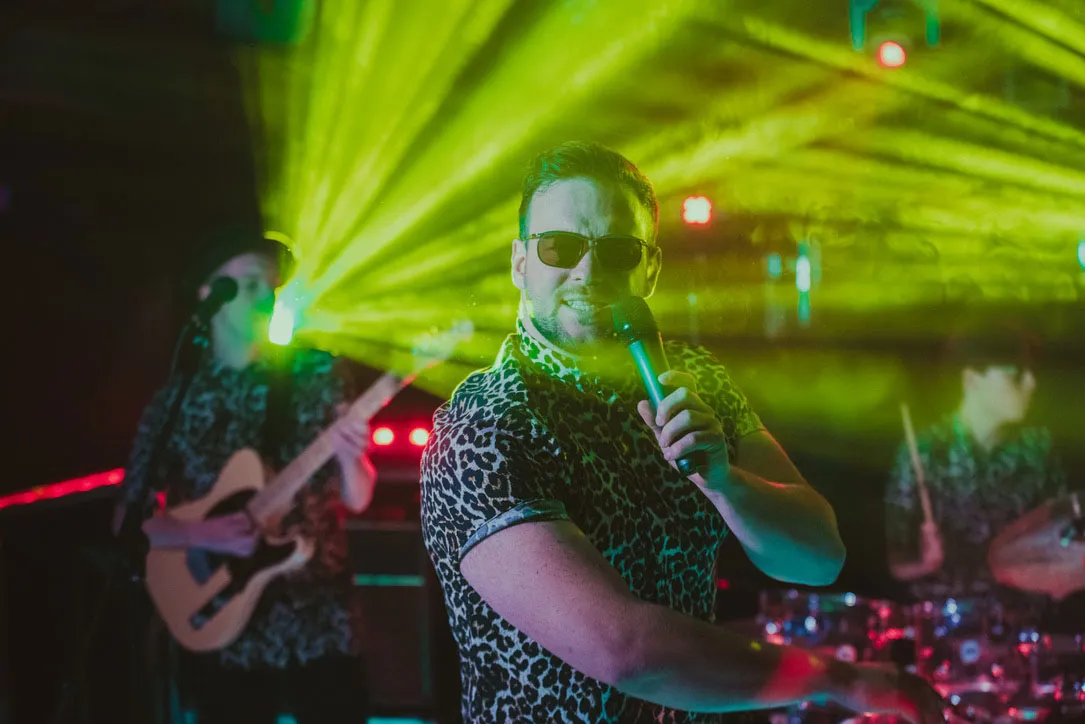 Singer performing live under bright green stage lights