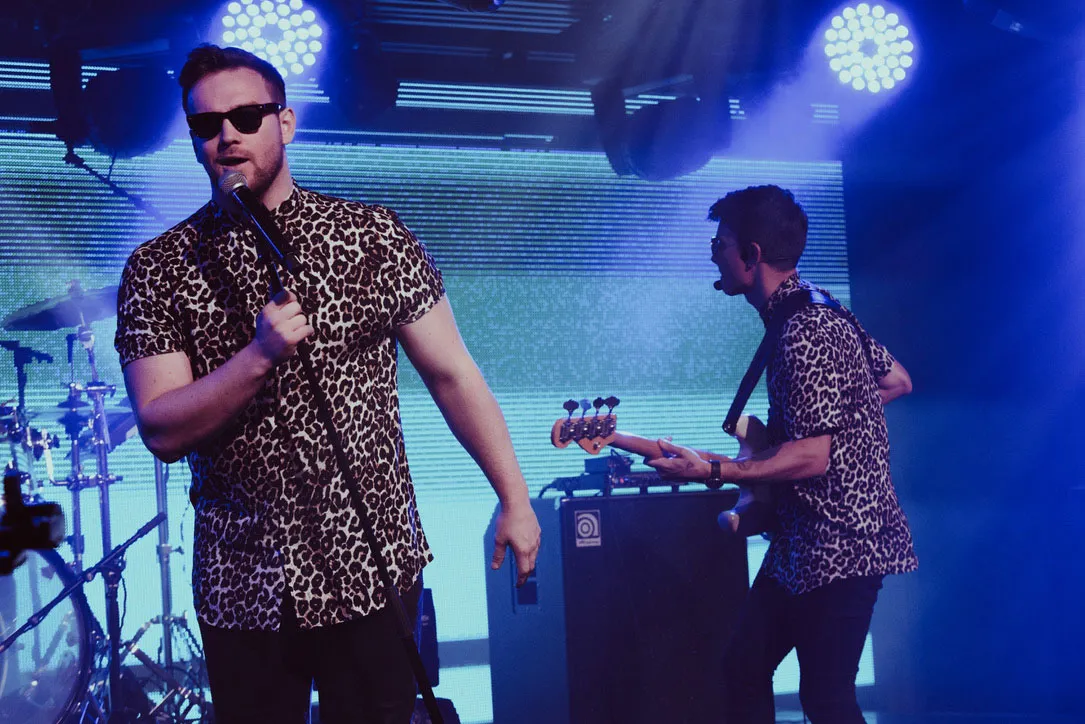 Singer performing live on stage with band