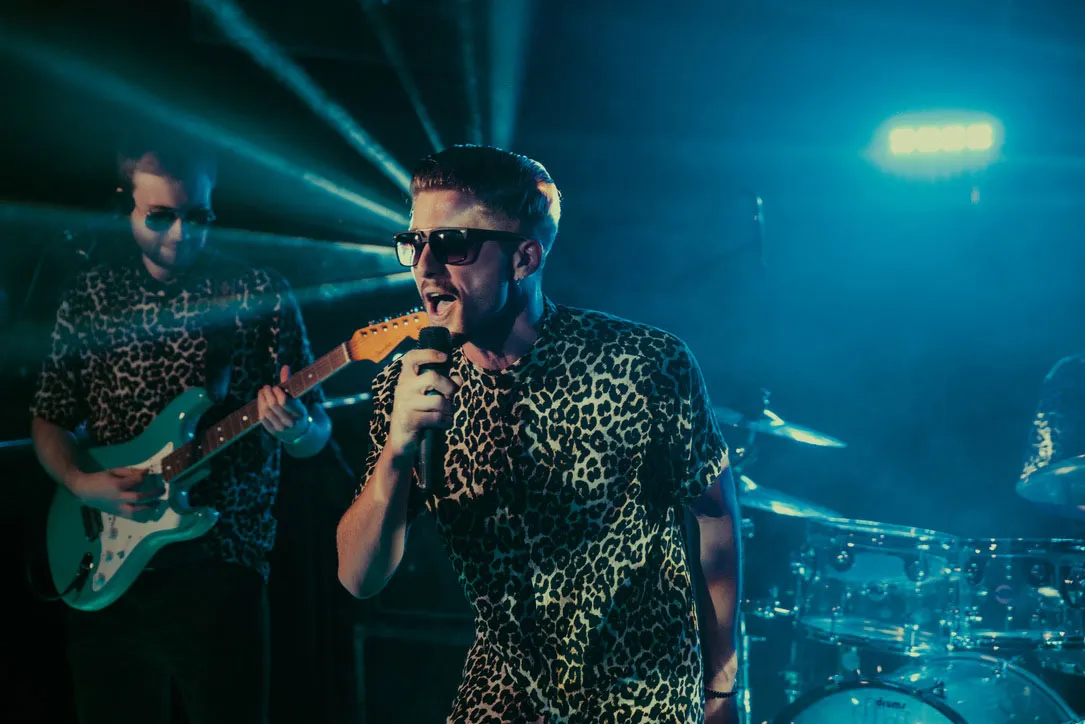 Singer wearing sunglasses performing live on stage